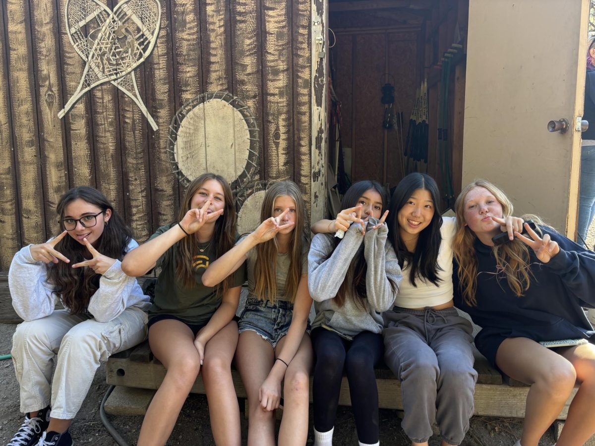 Some of the seventh grade girls and eighth grade girls sitting before archery tag. 
